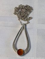 Pendant and chain laid flat showing design and stone