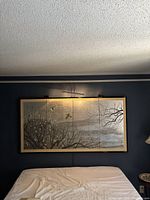Full frontal view of the two-panel folding screen mounted on wall above bed
