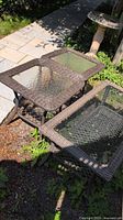 Three outdoor deck tables grouped together on ground. Two smaller square side tables and one larger rectangular coffee table with rattan frames and glass tops in sunlight.