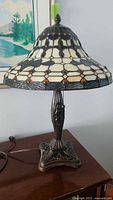 Full view of the Tiffany style table lamp showing stained glass style dome shade, metal base, and pull chains.