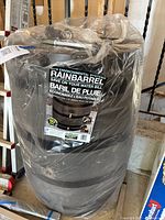 Photo showing the boxed, wrapped rainbarrel with label visible describing the product name RTS Environmental Systems Rainbarrel saving on water bill.