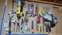 Full view of pegboard with assorted hand tools including hammers, cutters, pliers, work light, and levels.