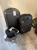 Overview of all items in the lot showing suitcase, travel bag, and pillows.