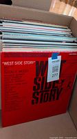 Box of vinyl records showing red cover of West Side Story soundtrack album by Natalie Wood.