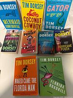 Photo showing 9 Tim Dorsey paperback books laid out, titles visible.