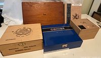 Photo showing the full set of five cigar boxes arranged together, various brands and sizes visible