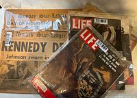 Photo of newspapers including Sunday Star-Ledger, Newark Star-Ledger with Kennedy headline, with Life and Collier's magazines in protective bags.