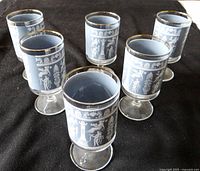 Set of six vintage footed glasses showing blue design with white Grecian figures and gold rims; 4.5 inches high