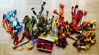 Overall view of numerous embroidery floss skeins in assorted colors spread on the floor, including blues, greens, oranges, reds, yellows, browns, and purples, some loose and some bundled.