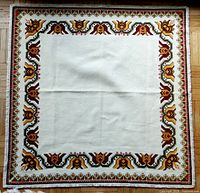 Full view of the square embroidered table mat showing entire design and colors.