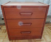 Front view of three-drawer teak nightstand with integrated handles