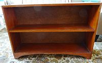 Front view of the vintage solid wood shelf showing two open compartments and its reddish-brown finish.