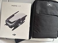 Retail box labeled 'Mavic Air' next to grey drone carry backpack.