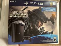 Front of original retail box for PS4 Pro Call of Duty: Modern Warfare bundle, shows console image, DualShock controller, and 1TB badge