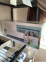 Photo of the Silhouette Cameo electronic cutting tool box displayed on a shelf, showing branding and packaging design.
