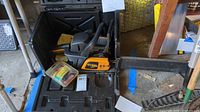 Poulan Pro chainsaw inside open black plastic carrying case with extra cutting chain and paperwork.