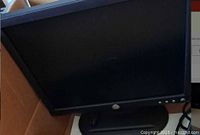 Front view of Dell 17-inch monitor with screen off, showing Dell logo and control buttons.