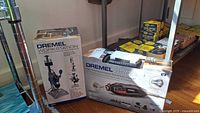 Boxes showing the Dremel 4200 rotary tool and the Dremel 220-01 Workstation tool holder with original packaging and product images