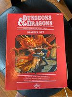 Front and top view of the Dungeons & Dragons Starter Set red box featuring fantasy artwork of a dragon and a warrior.