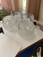 Four clear glass mugs with Nestle Nescafé etched branding visible from front and side.