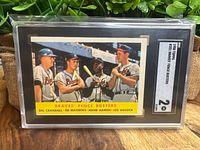 Photo of the front side of the 1958 Topps Braves' Fence Busters baseball card graded SGC 2 showing Del Crandall, Ed Mathews, Hank Aaron, and Joe Adcock.