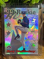 Front holographic refractor foil baseball card featuring Roy Halladay pitching in Toronto Blue Jays uniform.