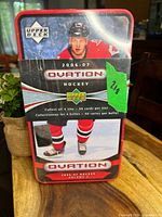Front view of the metal tin with promotional hockey player image and Upper Deck Ovation 2006-07 branding.