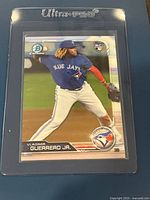 Front side of 2019 Bowman Chrome Vladimir Guerrero Jr rookie card showing player pitching in Blue Jays uniform in Ultra Pro sleeve.