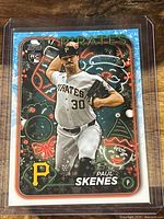 Front of 2024 Paul Skenes Topps Holiday rookie baseball card showing player pitching and holiday-themed border
