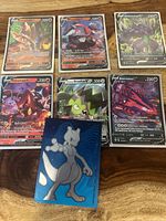 Seven Pokemon V cards (Zamazenta V, Hydreigon V, Grimmsnarl V, Volcanion V, Stunfisk V, Eternatus V) plus Mewtwo metallic card