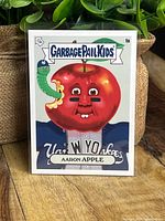 Front of Garbage Pail Kids Aaron Apple Aaron Judge baseball card showing cartoon apple with Yankees worm and label 1a Aaron Apple