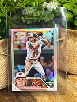 Front of the 2023 Topps Chrome Gunnar Henderson Rookie Refractor baseball card in protective plastic holder, showing player in batting stance with bright refractor shine.