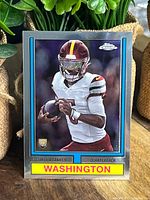 Front of 2023 Topps Chrome rookie card showing Jayden Daniels in Washington football uniform with rookie card insignia.