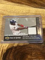 Trading card featuring Joe Carter batting and embedded swatch of game-used pants fabric.