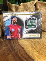 Close-up of Ken Griffey Jr 1999 MLB All-Star Game Commemorative Relic card featuring embroidered patch shaped like home plate with All Star Game 99 logo