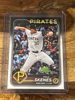 Front of the Paul Skenes baseball card showing player pitching in Pirates uniform, Topps branding, rookie card logo, and rookie debut date.