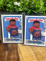 Two Garbage Pail Kids trading cards side-by-side featuring Ronald Acuna in bathroom setting, cards numbered 8A and 8B.