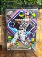 Front of Topps Cosmic Chrome Gunnar Henderson rookie card showing player swinging a bat against a cosmic themed background.