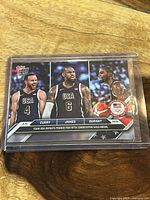 Front of the Topps Now 2024 Olympic Gold basketball card showing Curry, James, and Durant in Team USA uniforms.