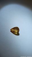Close-up of natural yellow sapphire pear cut gemstone showing color and inclusions.
