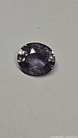 Oval cut natural untreated purple sapphire showing facets and color.