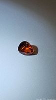Photo of pear cut fanta orange spessartite garnet showing its color and facets