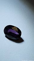 Oval cut deep purple Tanzanian spinel gemstone, showing rich color and clarity in natural light.