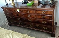 Front view of mahogany dresser with ten drawers and brass hardware