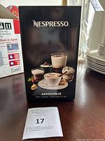 Front of the Nespresso Aeroccino3 box showing branding and product images of coffee with frothed milk.