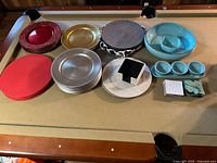 Overview of assortment of charger plates and serving ware including different colors and materials