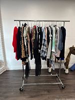 Full rack of assorted ladies tops in size large hung on a metal rolling rack, showing varied colors and prints.