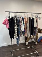 Full rack of assorted ladies tops all size medium, various colors and patterns visible.