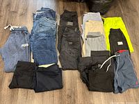 Full view of assorted men's pants and shorts including jeans, sweatpants, dress pants and athletic shorts.