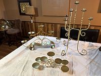 All three candelabras displayed on a white cloth, showing different styles and sizes